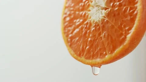 Drop of juice falls from the edge of a beautiful juicy tangerine. Stock Footage 147136806