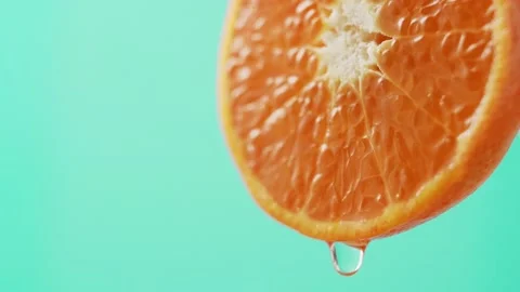 Drop of juice falls from the edge of a beautiful juicy tangerine. Stock Footage 147139822
