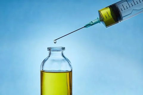 A drop of liquid drips from the needle of a Stock Photos