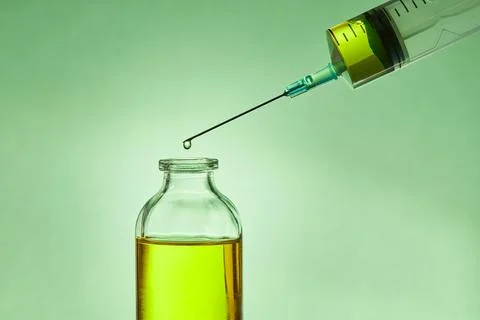 A drop of liquid drips from the needle of a Foto stock
