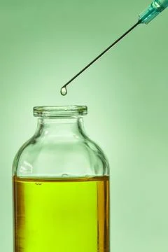 A drop of liquid drips from the needle of a Stock Photos