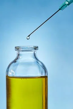 A drop of liquid drips from the needle of a Stock Photos