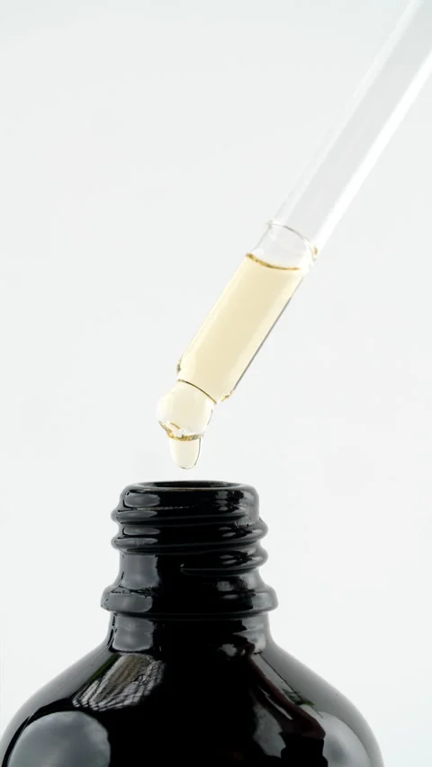 Drop of liquid falling from pipette into bottle Stock Footage 311025574