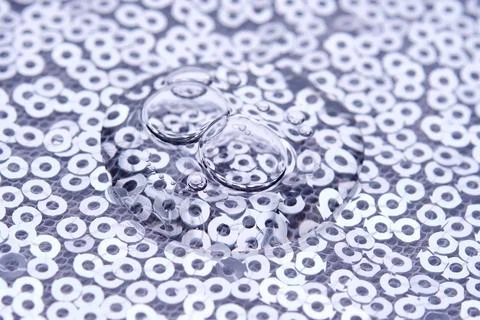 A drop of makeup on a background of silver sequins. Stock Photos