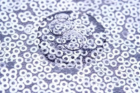 A drop of makeup on a background of silver sequins. Stock Photos
