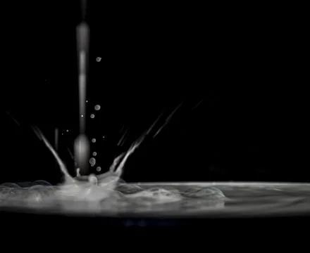 Drop of milk with big waves on surface with black background Stock Photos