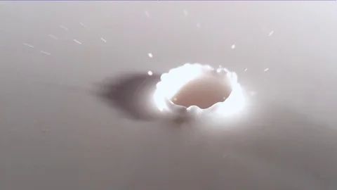 Drop of milk falling, splashing and causing ripples in slow motion Stock Footage 81228399
