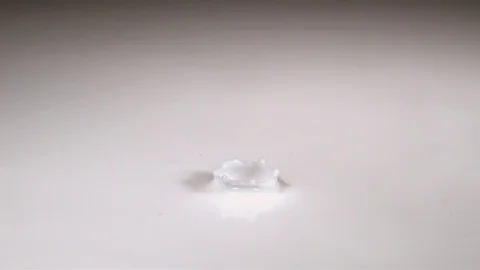 Drop of milk falling, splashing and causing ripples in slow motion Vídeos de archivo 81228646