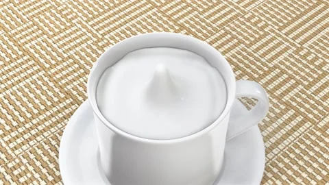 Drop of milk falls into an already full cup Stock Footage 143865552