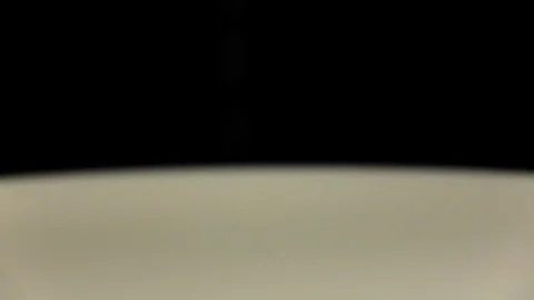 Drop milk falls to surface in slow motion. Super closeup Stock Footage 76149804