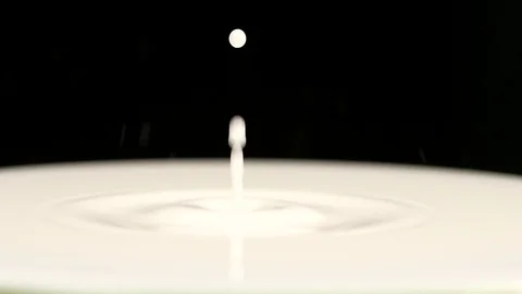 Drop of milk falls to surface. Super closeup. Slow motion Stock Footage 76145673