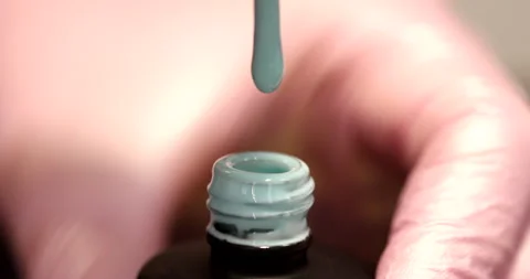A drop of nail polish drips into an open bottle. Stock Footage 149896980