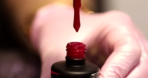 A drop of nail polish drips into an open bottle. Stock Footage 149897004