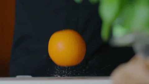 Drop of orange in slow motion. Splashing water droplets. On the kitchen. Stock Footage 131320283