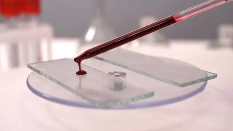 Drop red liquid in test glass rotating on the special equipment Stock Photos