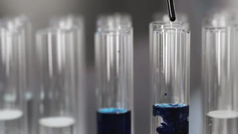 Drop of sample of blue liquid into a test tube in the laboratory. Stock Footage 302173459