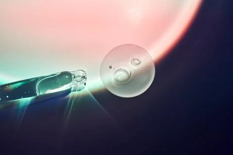 A drop of serum for the face on the border of light and shadow. Stock Photos