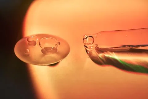 A drop of serum for the face on the border of light and shadow. Stock Photos