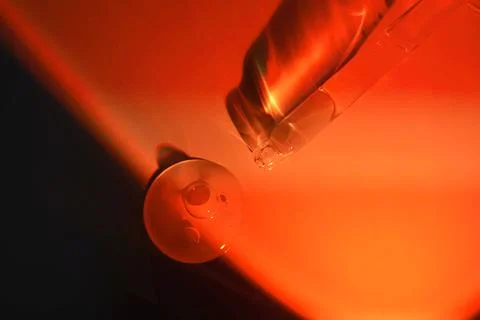 A drop of serum for the face on the border of light and shadow. Stock Photos