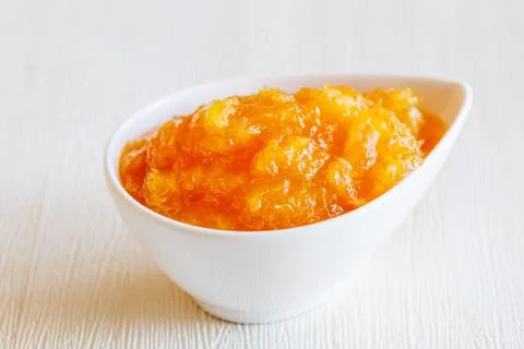 Drop shape white ceramic Bowl of homemade orange jam isolated on white Stock Photos