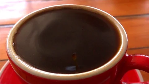 A drop slowly falls into a coffee cup Stock Footage 121652930