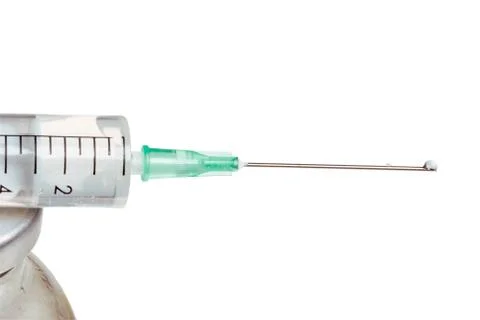 Drop on a syringe needle. Stock Photos