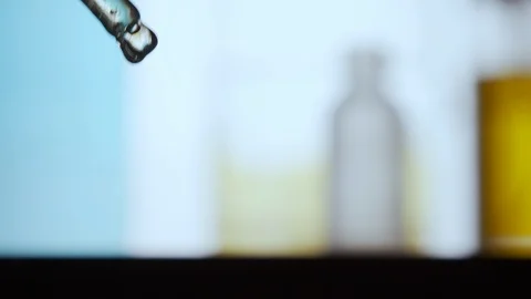 Drop of thick fluid falling from liquid dropper. Color background 스톡 동영상 120819075