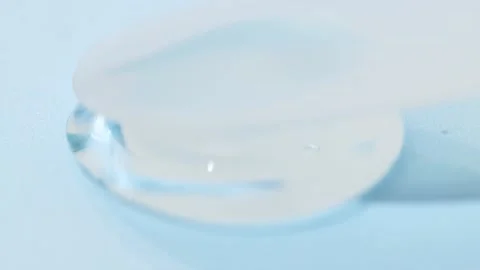 Drop of transparent gel on a blue background close-up. Liquid cosmetic product Stock Footage 232371385