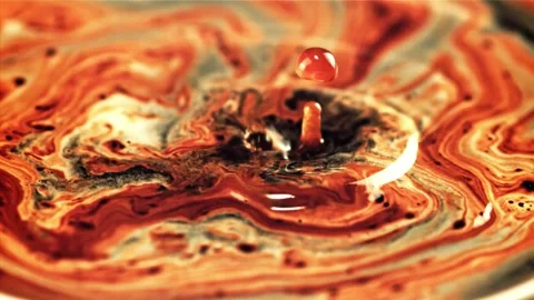 Drop in vibrant paint creates ripple effect with slow motion capture Stock Footage 327575470