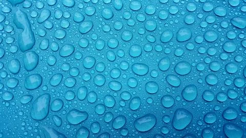 Drop of water on a blue background. Stock Photos