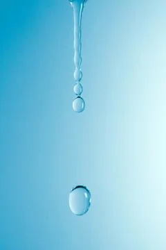 A drop of water on a blue gradient background Stock Photos
