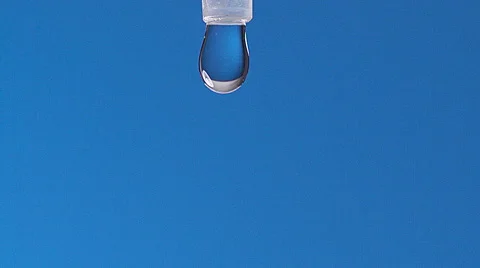 Drop of Water falling against Blue background, Slow motion Stock Footage 67760523