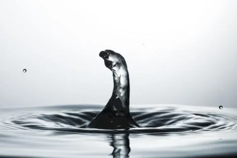Drop of water falling down in the water Stock-Fotos