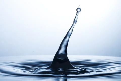 Drop of water falling down in the water 스톡 사진