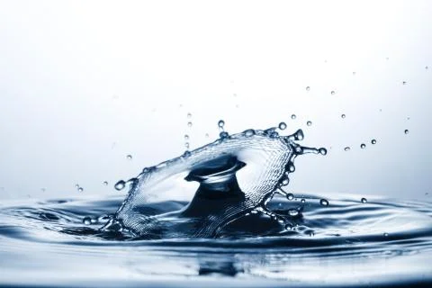 Drop of water falling down in the water Fotos de archivo