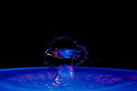 Drop of water falling down in the water Foto stock
