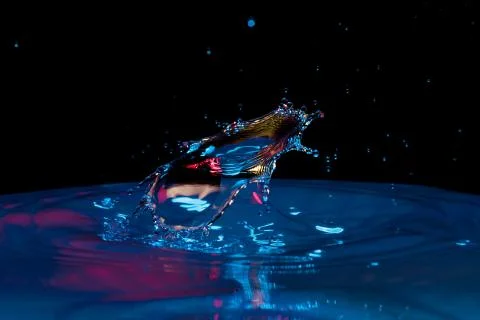 Drop of water falling down in the water Stockfoto's