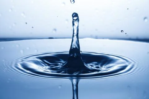 Drop of water falling down in the water 스톡 사진