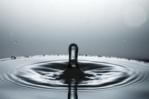 Drop of water falling down in the water Foto stock