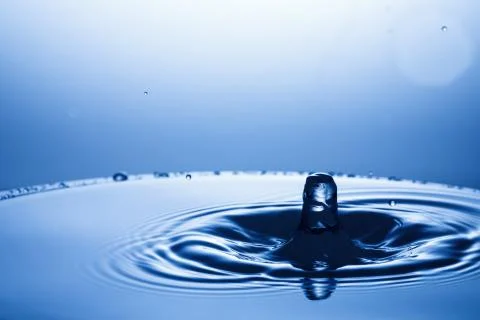 Drop of water falling down in the water Stockfoto's