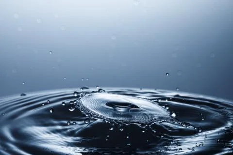 Drop of water falling down in the water Fotos de archivo