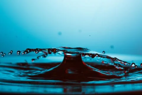 Drop of water falling down in the water 스톡 사진