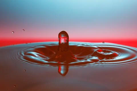 Drop of water falling down in the water 스톡 사진