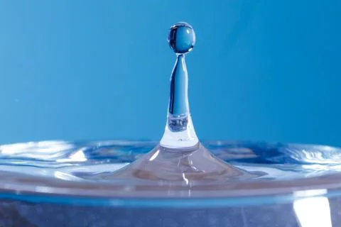 Drop of water falling down in the water Fotos de archivo