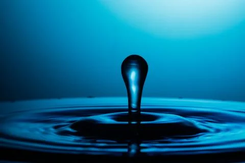 Drop of water falling down in the water Foto stock