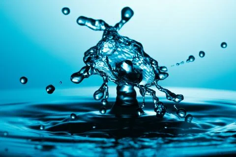 Drop of water falling down in the water 스톡 사진