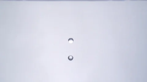 Drop of water falling into a puddle of water in slowmotion HD Stock Footage 99233584