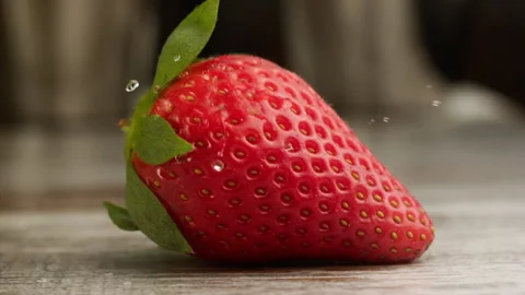 Drop of water falling on strawberry in slow motion Stock Footage 156202065