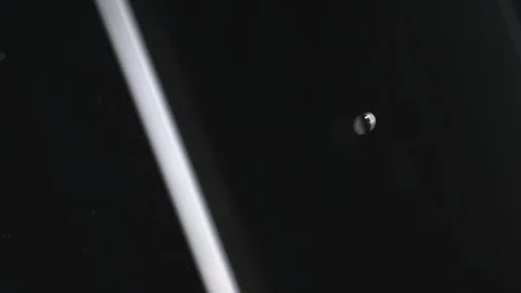 Drop of water falling into water against black background Stock Footage 107948452
