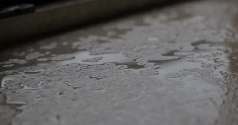 Drop of water falling on a wet floor. close-up of puddle on a floor Stock Footage 339201118